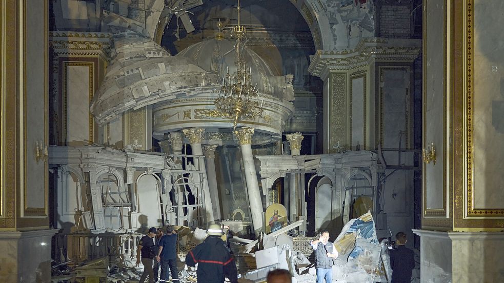 Menschen gehen im Inneren der Verklärungskathedrale von Odessa, die bei einem russischen Raketenangriff schwer beschädigt wurde. Foto: dpa/AP