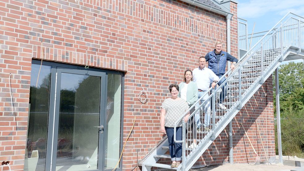 Diese Treppe führt auf eine große Balkonterrasse, die für alle Bewohner offen ist. Die Bauphase haben (von links) Pflegedienstleiterin Sandra Groth, Schutzengel-Huus-Leiterin Sylvia Dojen, Bauplaner Hermann Pleis und Förderverein-Vorsitzender Ulf Thiele hautnah miterlebt. Foto: Lüppen