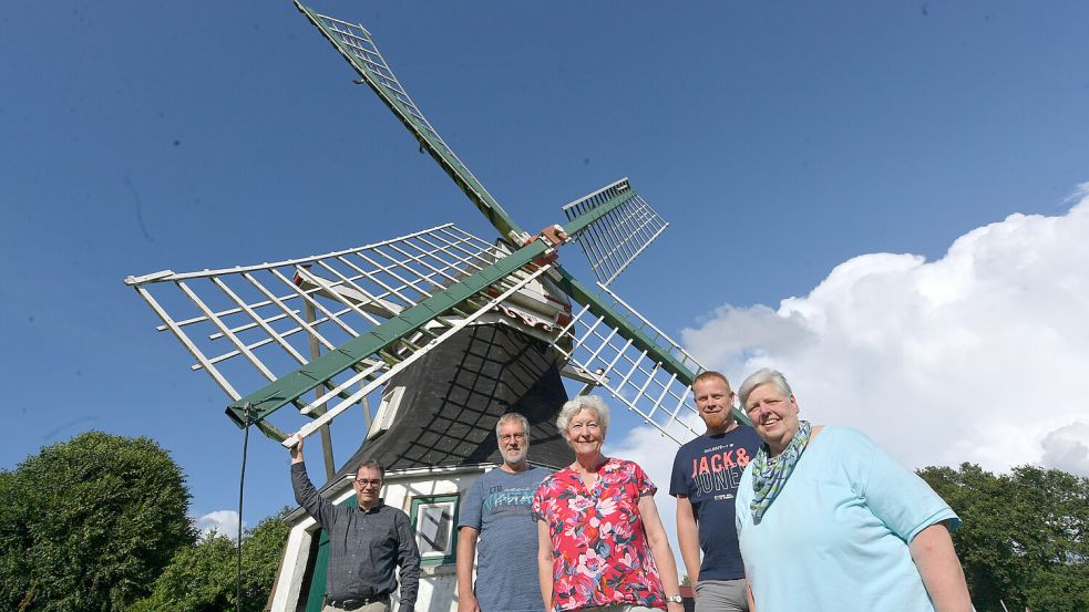 Aus dieser Perspektive fällt nicht auf, wie klein die Mühle in Tannenhausen ist. Vor ihr posieren (von links): Matthias Klattenberg (Mühlenverein), Pastor Uwe Noormann, Ortsbürgermeisterin Gerda Küsel, Klaus Hallenga (Boßelverein) und Hannelore Schmidt (Reitsportverein). Foto: Ortgies