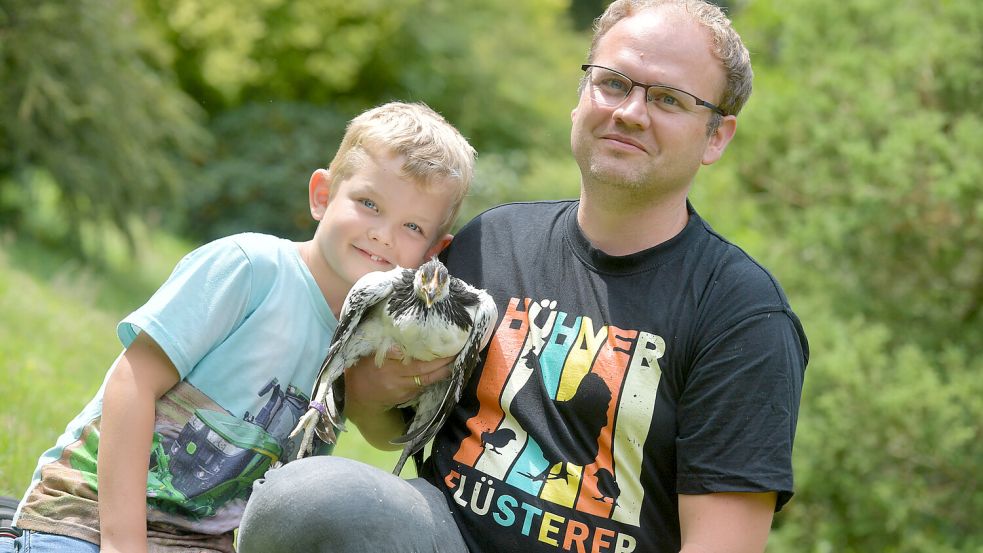 Holger Janssen und sein Sohn Ilias (7 Jahre) kommen aus Sandhorst und sind mit einem Lakenfelder Huhn angereist. Das ist eine lebhafte und athletische alte Haustierrasse. Die Hühner können sogar noch auf Bäume fliegen. Foto: Ortgies