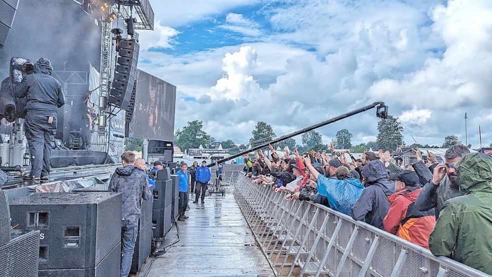 Das WOA 2023 und den Matsch wird man wohl für die Ewigkeit miteinander in Verbindung bringen – aber nicht mit einer getrübten Wacken-Stimmung, wie hier Metalheads in bester Laune trotz des Regens vor der Headbangers Stage beweisen. Foto: Nicolas Fromm