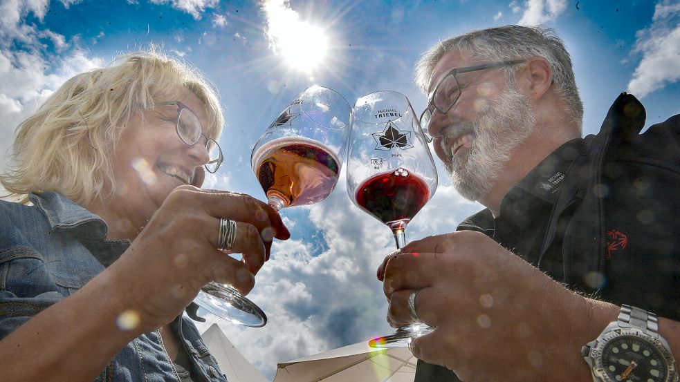 Der Pfälzer Weinhändler Christian Reznicek stößt mit der Auricherin Birgit Bergmann aufs Weinfest an. Foto: Ortgies