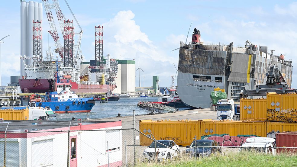 Der schwerbeschädigte Autofrachter “Fremantle Highway“ liegt in Eemshaven, abgeschirmt durch gelbe Container. Gut eine Woche nach Ausbruch des Feuers war das etwa 200 Meter lange Schiff am Donnerstag über Stunden zu dem Hafen geschleppt worden. Foto: Penning/DPA