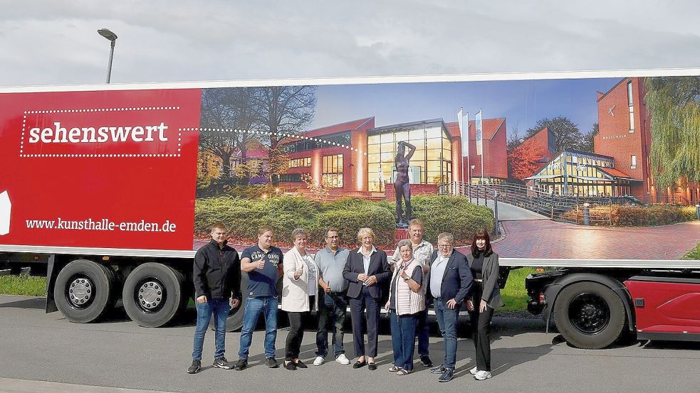 Auf der anderen Fahrzeugseite ist eine Außenansicht der Kunsthalle zu sehen. Eske Nannen (Fünfte von links), Spediteur Markus Köhler (links neben ihr), das Ehepaar Merkel (rechts neben ihr) und Thorsten Boelen (Zweiter von rechts) stellten die Gestaltung zusammen mit Fahrern und Mitarbeitern vor. Foto: Stromann