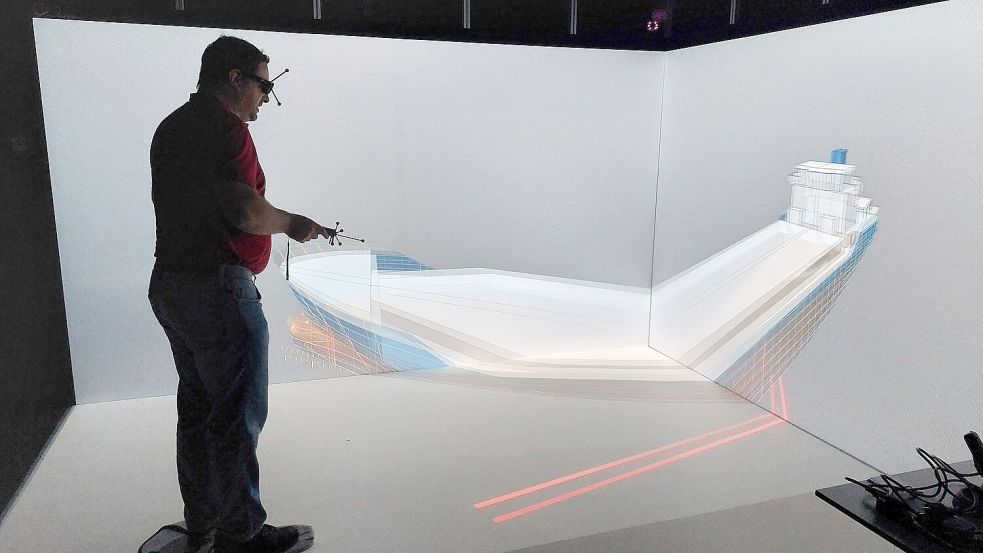 Lars Ostrowitzki führt durch den virtuellen Raum. Hier schaut er sich durch seine Virtual-Reality-Brille einen Frachter in 3D an und überprüft diesen auf Schwachstellen.