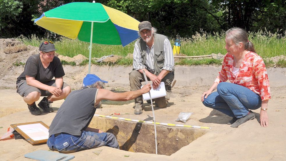 Umgeben von Amelie Mohrs (knieend, von links), Axel Prussat und Dr. Sonja König vom Archäologischen Dienst der Ostfriesischen Landschaft vermisst Grabungshelfer Thomas Haehner Spuren im Boden, die darauf deuten, dass sich dort ein Brunnen befand. Foto: Ullrich