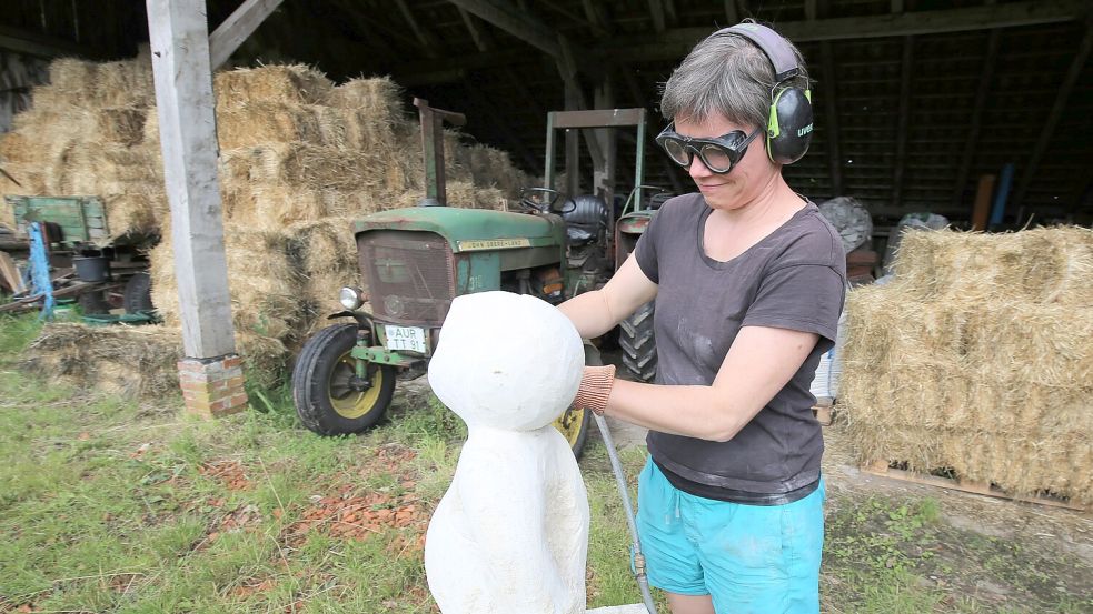 Daniela Eerkens bei der Arbeit. Sie ist gelernte Steinbildhauerin und verwandelt Sandsteinblöcke in kleine Badegäste. Foto: Böning