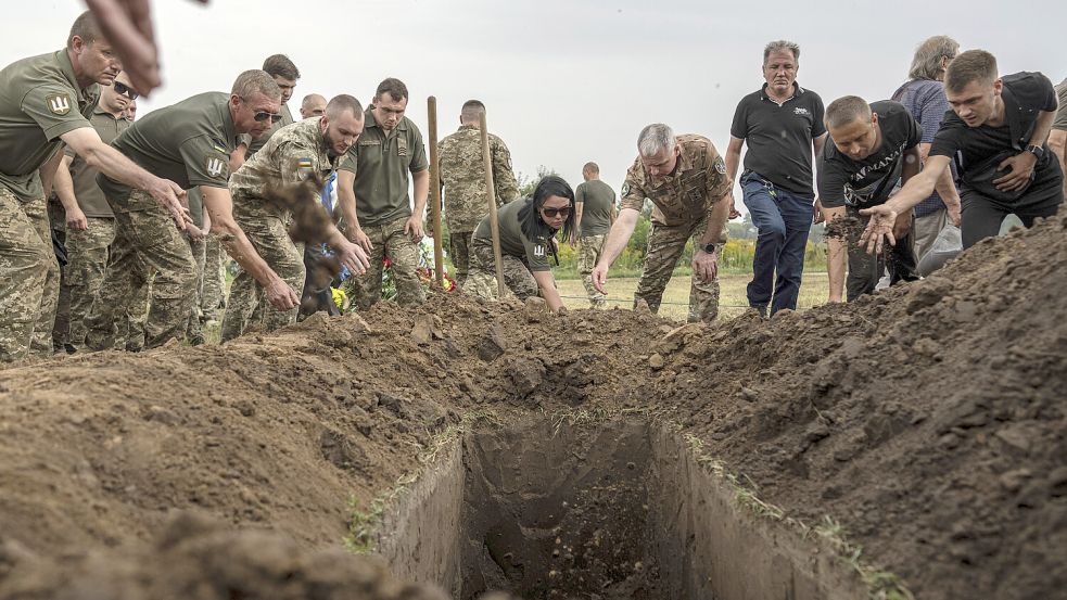 Das Sterben geht weiter: Ukrainische Soldaten beerdigen einen Kameraden. Foto: picture alliance/dpa/AP/Evgeniy Maloletka