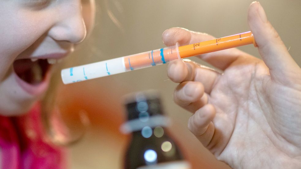 Eine Mutter verabreicht ihrer Tochter eine Dosis Fiebersaft. Unter anderem Schmerzsäfte für Kinder waren während der letzten Infektionswellen im Winter knapp. Foto: Schmidt/DPA