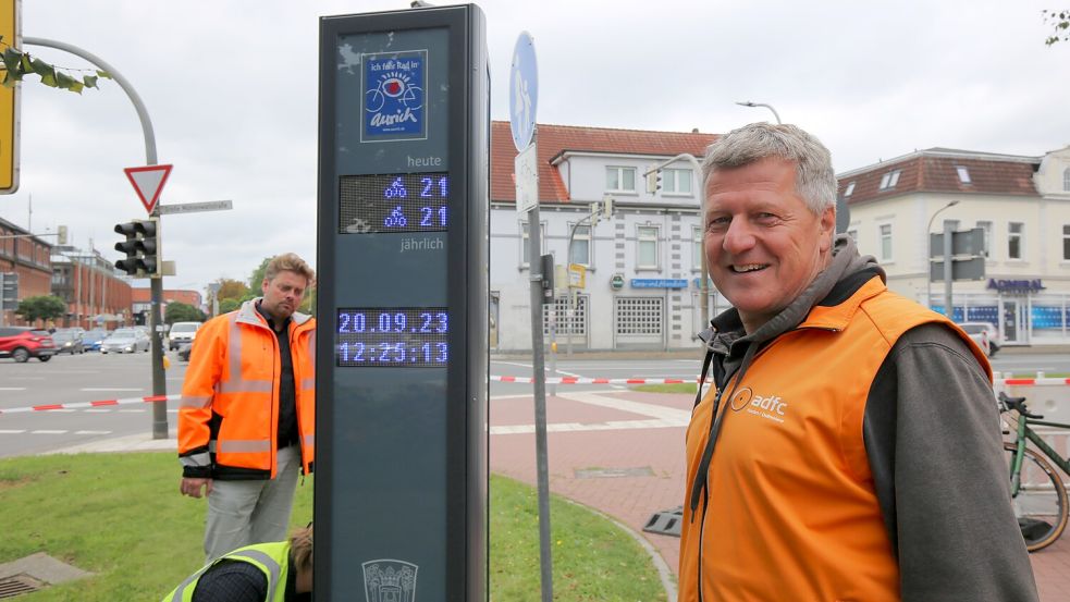 Aurichs Radverkehrsbeauftragter Frank Patschke vor dem frisch installierten Display an der Ostertorkreuzung. Im Hintergrund sein Stadtradeln-Konkurrent Christian Erdwiens vom Tiefbauamt in Aurich. Foto: Böning