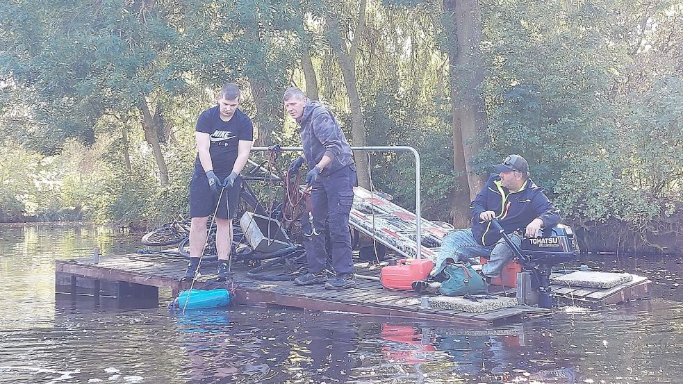 Samuel Böer (von links), Holger Schwarzenburg und Michael de la Chaux vom WSV Barenburg bargen mit einem Ponton Fahrräder, einen Kinderwagen und einen Baustellenzaun. Fotos: Hanssen