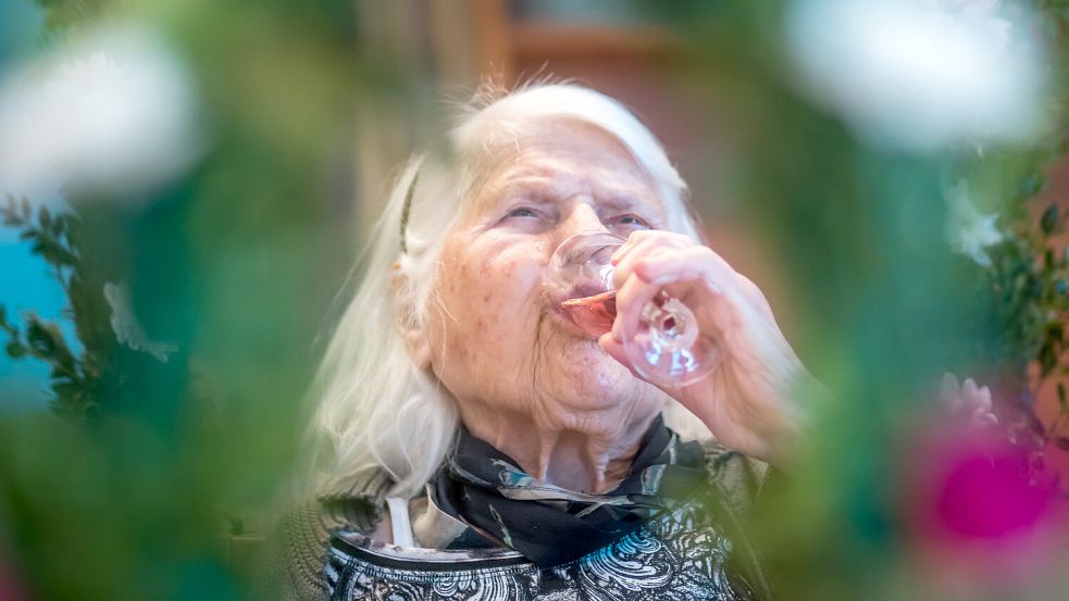 Nachdem sie mit ihren Freunden angestoßen hat, gönnt die Jubilarin sich den Sekt.