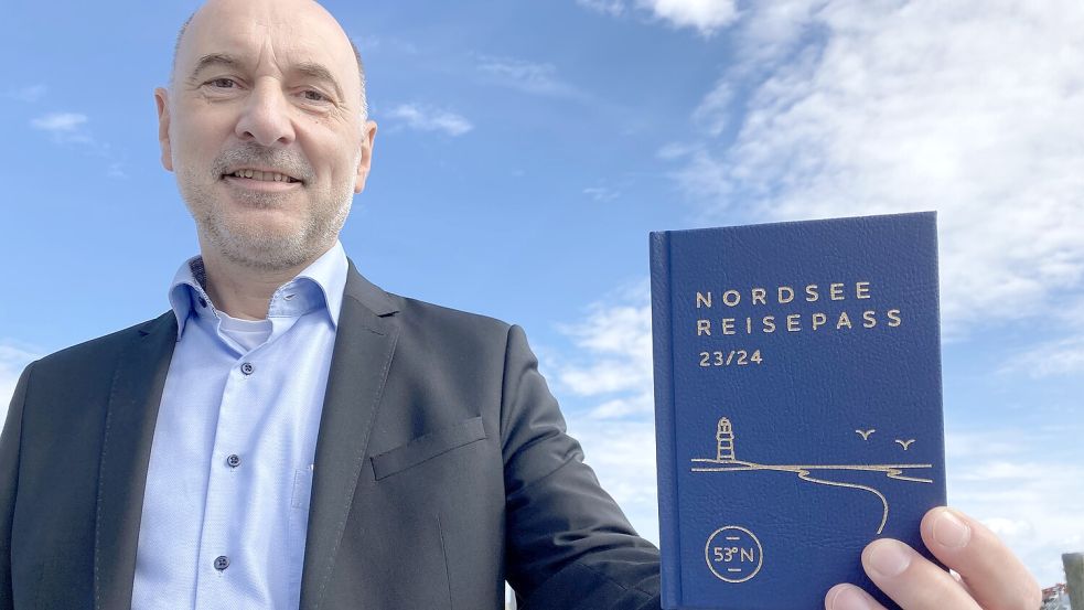 Mario Schiefelbein mit einem Nordsee-Reisepass. Das kleine Büchlein ist echten Reisepässen nachempfunden. Foto: Oltmanns