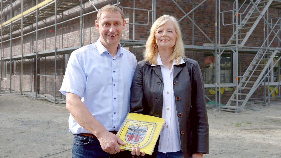 Zur Begrüßung erhält Dr. Daniela Neumann ein Geschenk von Bürgermeister Heinz Trauernicht. Im Gebäude hinter ihr soll die Praxis in Remels eingerichtet werden. Foto: Lüppen
