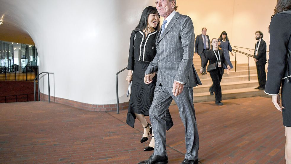 Altbundeskanzler Gerhard Schröder (M, r) und seine Frau verlassen den Festakt anlässlich der Feierlichkeiten zur deutschen Wiedervereinigung in der Elbphilharmonie. Foto: Pool AP/dpa