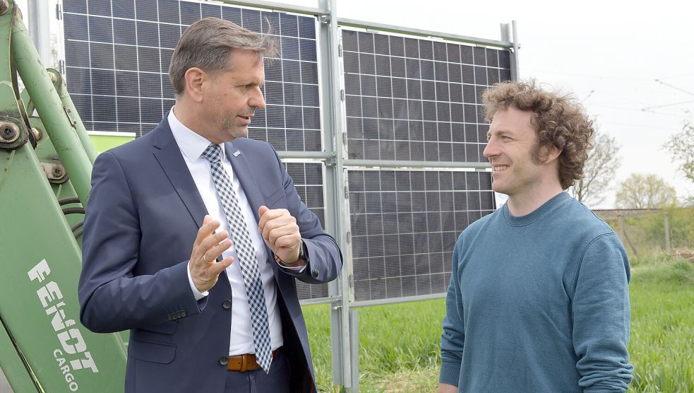 Niedersachsens Minister Olaf Lies (links) besichtigte im Jahr 2022 das Pilotprojekt „Agri-PV Dörverden“, bei dem senkrecht aufgestellte Solarmodule auf der Ackerfläche platziert werden. Der Minister unterhält sich auf dem Foto mit mit Corbinian Schöfiniu von der Klimaschutz- und Energieagentur Landkreis Verden. Archivfoto: Michael Bahlo/dpa