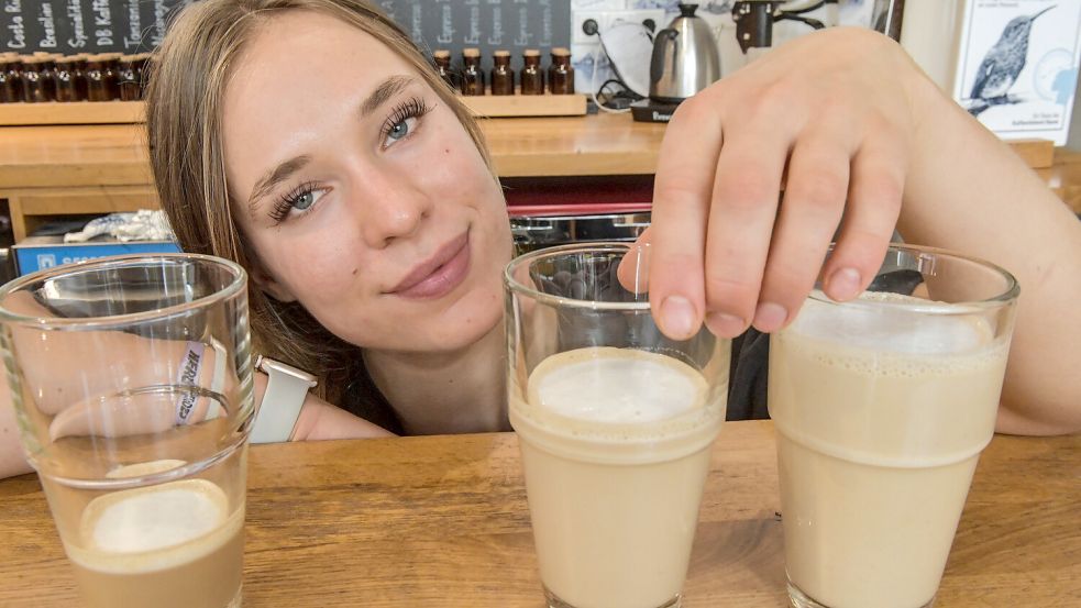 Maya Jakubowski zeigt in der Kaffeerösterei Baum, was es bedeuten würde, wenn zwölf Prozent weniger im Latte Macchiato wäre. Die Mehrwertsteuer für Gastronomiebetriebe soll von sieben auf 19 Prozent steigen. Foto: Ortgies