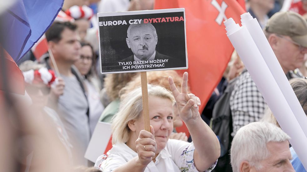 Eine Frau hält auf dem „March of a Million Hearts“ in Warschau ein Plakat mit einem Bild von PiS-Parteichef Kaczynski und dem Präsidenten von Belarus Alexander Lukashenko mit der Aufschrift „Europa oder Diktatur“ hoch. Foto: imago images/Volha Shukaila