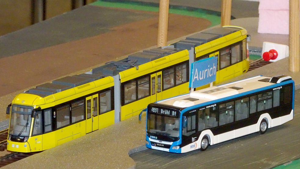 Das Foto zeigt das Modell eines Schienenfahrzeugs für die Strecke von Aurich nach Emden, daneben zum Vergleich einen Linienbus. Foto: Luppen