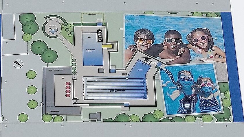 Auf dem Plakat vor dem Freibad ist aufgezeigt, wie es in Zukunft wieder auf dem Gelände aussehen soll.