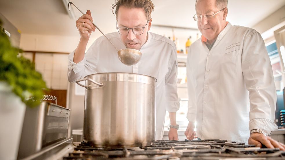 Noch kochen Henning Wagner (links) und sein Vater Erich auf einem Sechs-Flammen-Gasherd, der inzwischen etwa 30 Jahre alt ist. In Kürze müssen beide sich umgewöhnen. Fotos: Cordsen