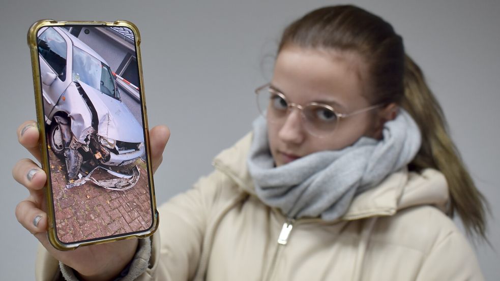 Die 20-jährige Chantal Hinrichs zeigt auf ihrem Smartphone das Bild des total demolierten VW Polos. Es war ihr erstes Auto. Sie hatte es sich erst vor Kurzem gekauft. Foto: Zein