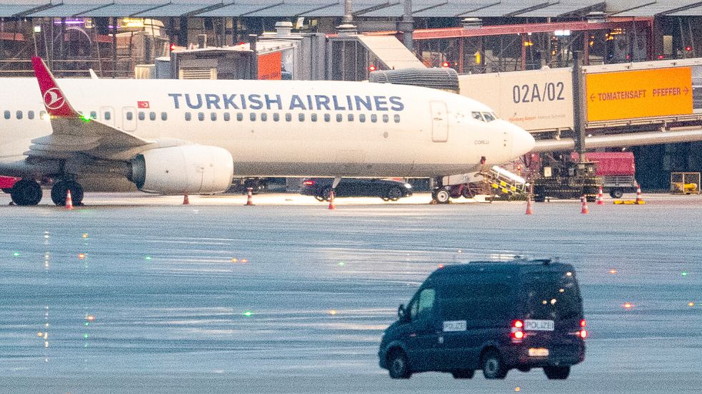 Ein Polizeifahrzeug steht auf dem Flughafen in Hamburg vor einem Flugzeug, an dem ein Auto mit einem Geiselnehmer steht. Ein bewaffneter Mann hielt auf dem Airport seine vierjährige Tochter in seiner Gewalt. Hintergrund soll nach Polizeiangaben ein Sorgerechtsstreit sein. Foto: Daniel Bockwoldt/dpa