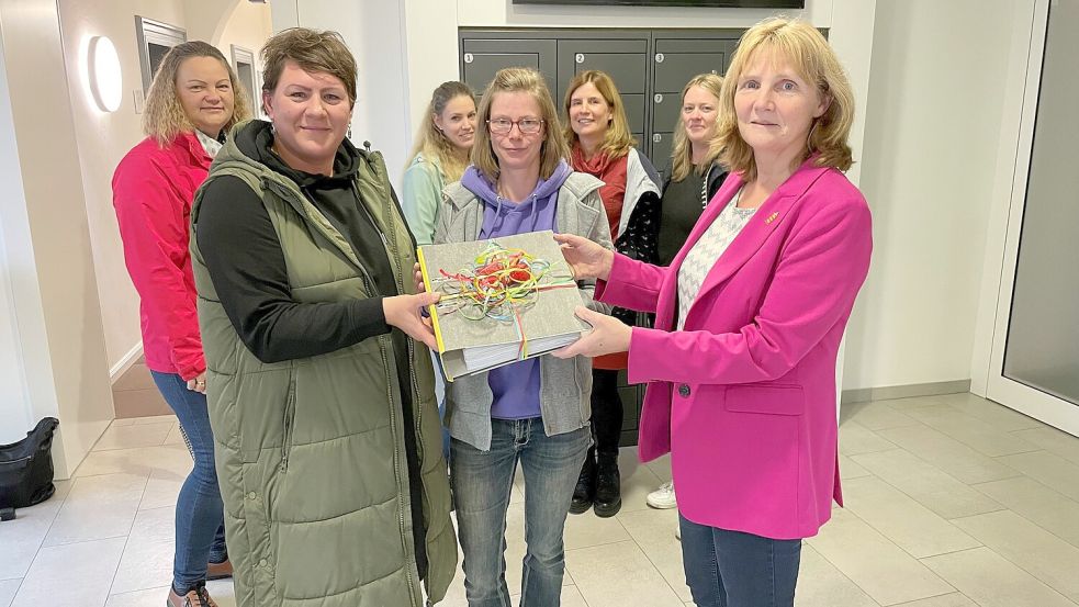 Melanie Remijn (vorne, von links) und Stefanie Doolmann bei der Übergabe der Unterschriften an die Krummhörner Bürgermeisterin Hilke Looden (parteilos). Foto: Weiden/Archiv