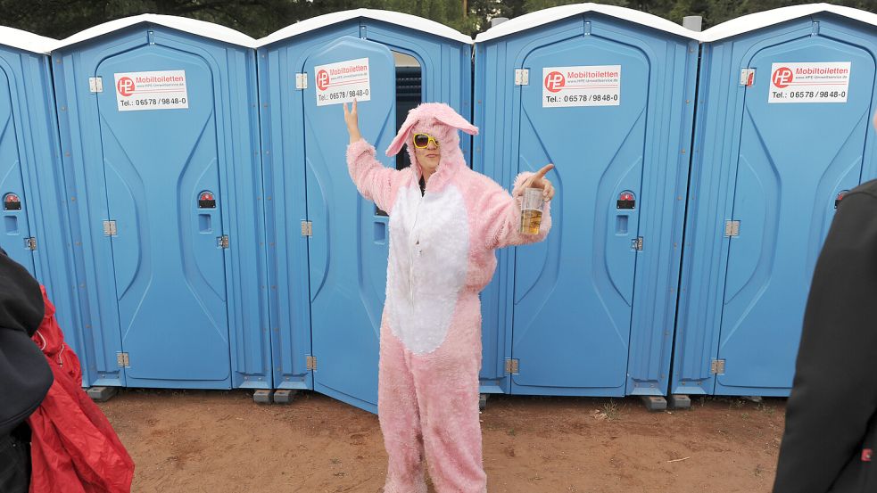 Eine als Hase verkleidete Frau kommt beim Hurricane-Festival in Scheeßel von der Toilette. Mobile Toiletten sind von Festivals nicht wegzudenken. Foto: Stratenschulte/dpa