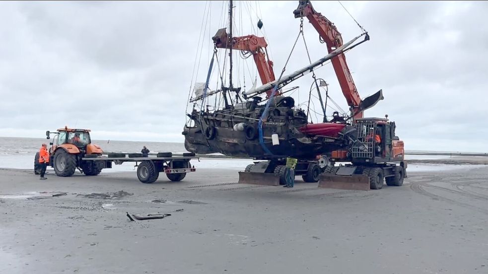 Mit zwei Kränen und einem Trecker wurde das als „Geisterschiff“ berühmt gewordene Boot am Freitag geborgen. Foto: Nordeneyer Wetter TV