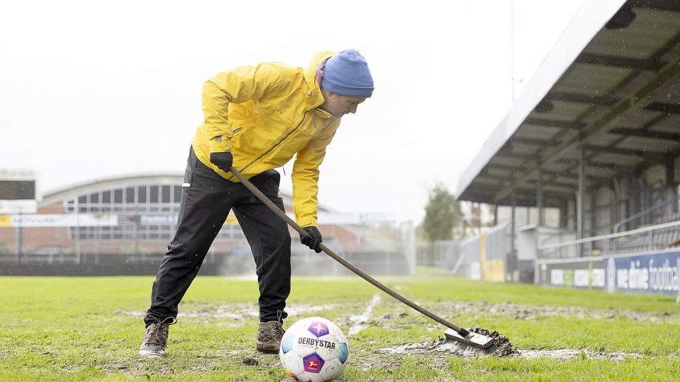 Mit dem Besen kämpft der BSV Kickers gegen Matsch und Pfützen. Foto: Bruns