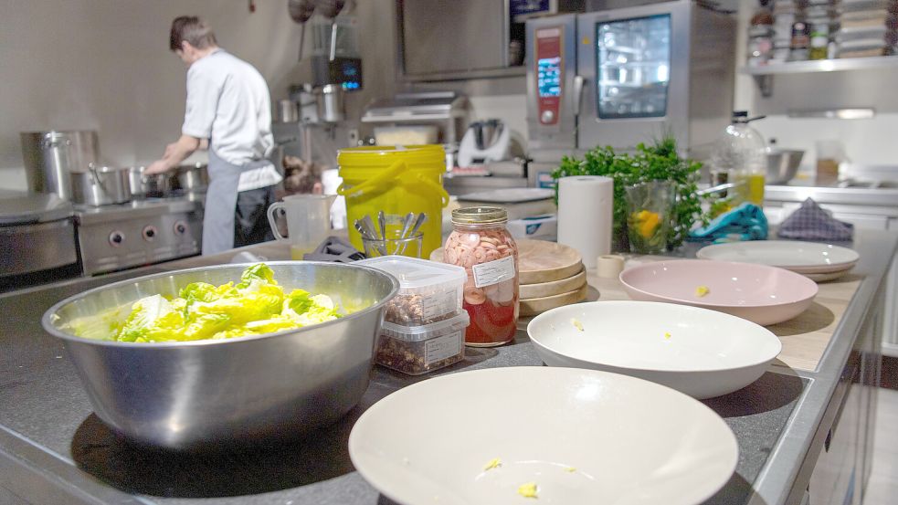 Ein Koch steht in einer Restaurantküche am Herd und kocht. Foto: Skolimowska/DPA