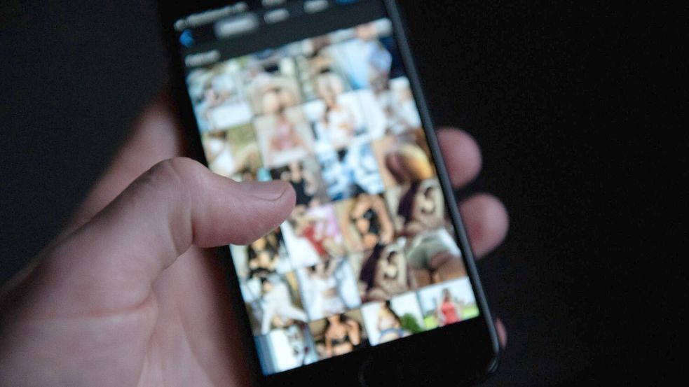 Auf einem Smartphone sind pornografische Bilder zu sehen. Foto: Archiv/Silas Stein/dpa