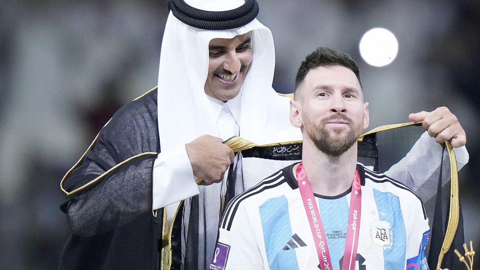 Ein Bild, das um die Welt ging: Der Emir von Katar, Tamim bin Hamad Al Thani, hängt Fußballstar Lionel Messi nach dem Gewinn der Weltmeisterschaft ein traditionelles Gewand um. Foto: Imago images/Jose Breton
