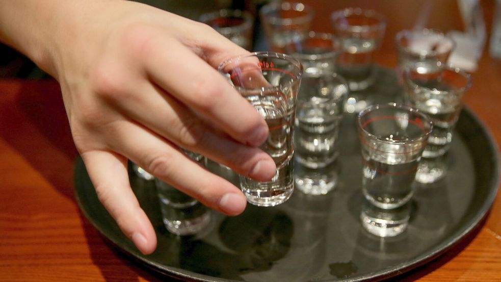 Die Hand eines Jugendlichen greift nach einem gefüllten Schnapsglas. Dieses Bild entstand in Hamburg. Foto: Heimken/dpa