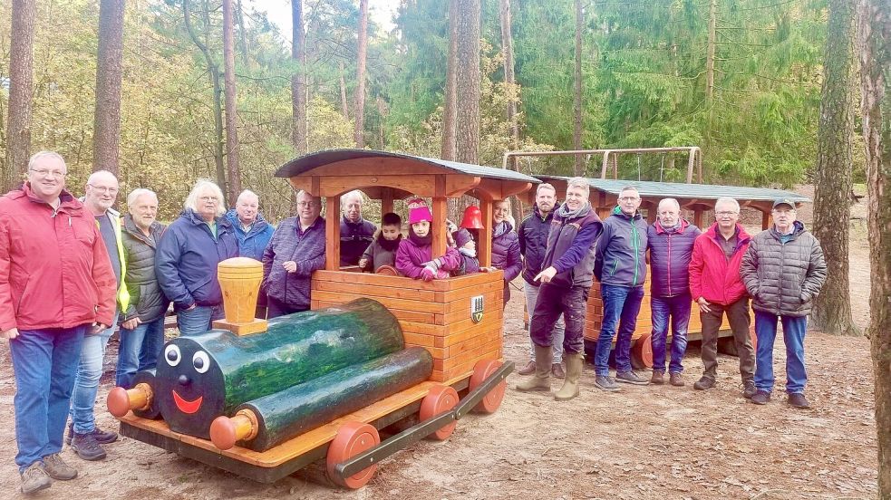 Für die Kinder ist klar: Die neue Lok ist großartig. Die Gattersägenfreunde und deren Gäste trafen sich zur offiziellen Übergabe im Heseler Wald (von links): Gerd Hollander, Hendrik Scholt-Albers, Uli Meyer (stellvertretender Vorsitzender des Fehntjer Bürgervereins), Egon Frühling, Bernd Schönnagel, Hans-Hermann Tebbens, Günter Saathoff (Gemeinderat Hesel), Andrea Nannen (stellvertretende Samtgemeindedirektorin), Andy Treyße (Bauamt Samtgemeinde Hesel), Gerd Dählmann, Andreas Janßen, Karl Busch, Leonhard Gottschlich und Erwin Köster (Gemeinderat Hesel). Foto: privat