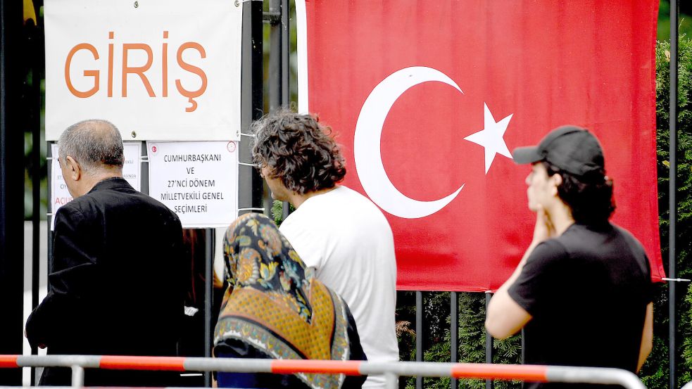 Passanten vor dem türkischen Generalkonsulat in Berlin: Der Staat rekrutiert und schickt Lehrer nach Deutschland. Daran gibt es viel Kritik. Foto: Britta Pedersen/dpa