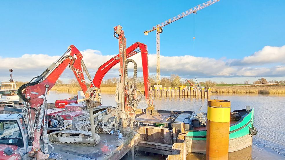 Um unter anderem Materialien vom Ufer aus besser zum im Bau befindlichen Pfeiler für die Hub-Drehbrücke im Fluss anliefern zu können, ist auf einer speziellen Arbeitsplattform, die sich größtenteils auch über der Ems befindet, aufgestellt worden. Foto: Deutsche Bahn