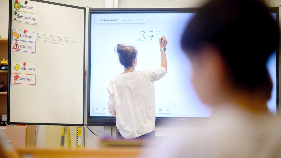 Eine Lehrerin schreibt eine Mathematikaufgabe auf eine digitale Schultafel. Gerade in Mathe schnitten deutsche Schüler besonders schlecht ab. Foto: dpa/Julian Stratenschulte