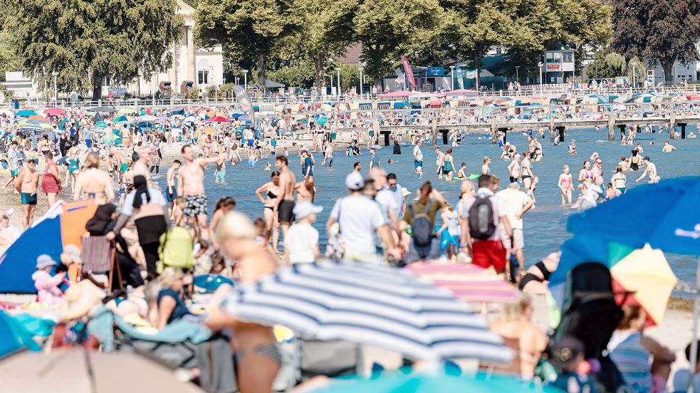 Badegäste genießen einen Hochsommertag am Strand von Travemünde. Foto: Scholz/dpa