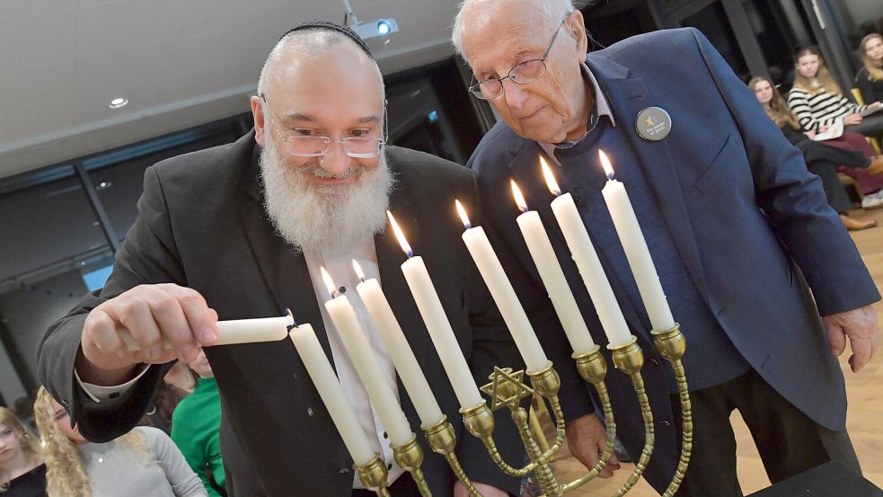 Kantor Baruch Chauskin (links) und der 98-jährige Holocaust-Überlebende Albrecht Weinberg entzünden gemeinsam die Kerzen der Chanukkia – des achtarmigen Leuchters. Foto: Ortgies