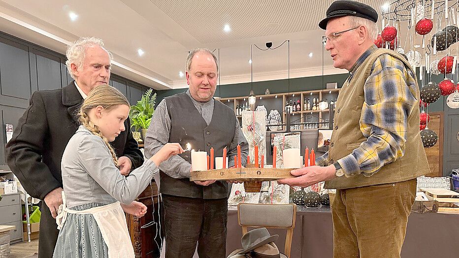 Johann Hinrich Wichern (Hermann Willms, von links) und Gesine (Bente Roelfs) zünden die Kerzen des ersten überlieferten Adventskranzes an. Der hatte noch für jeden der 24 Tage vor Weihnachten Kerzen. Gastwirt Enne Offers Buß (Heiko Janssen) und Landwirt Focko Gerdes (Enno Peters) sind dabei behilflich. Foto: privat