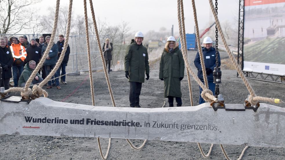 Hans Schrikkema (von rechts), Generalsekretär der Provinz Groningen, Ute Plambeck, Konzernbevollmächtigte der Deutschen Bahn AG für die Länder Hamburg, Schleswig-Holstein, Bremen und Niedersachsen, und Frank Doods, Staatssekretär im Niedersächsischen Ministerium für Wirtschaft, Verkehr, Bauen und Digitalisierung, vor der Schwelle, die die Drei kurze Zeit später symbolisch am Tau runterließen. Damit wurde symbolisch der Ausbau der Wunderline-Strecke gestartet. Fotos: Ammermann