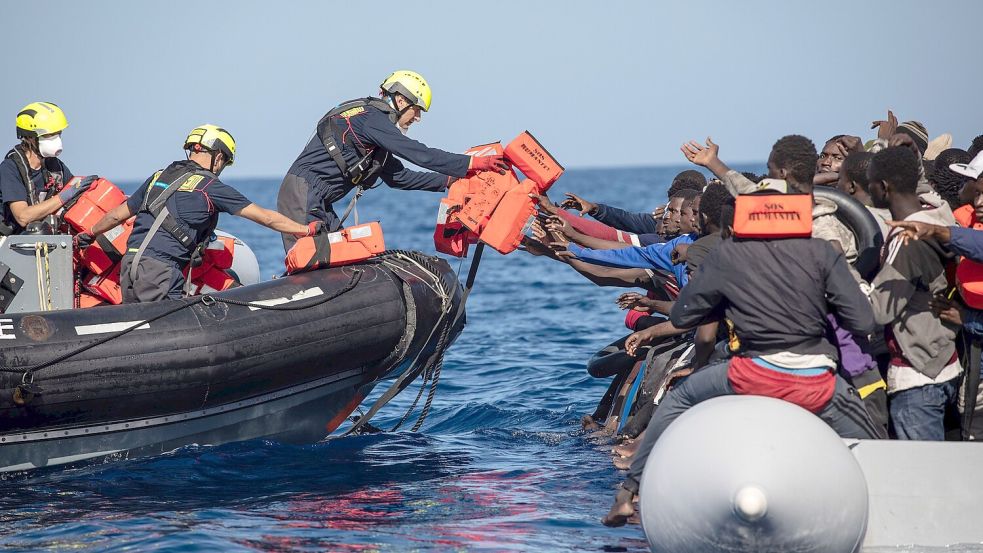 Die Seenotretter von der „Humanity 1“ reichen den Bootsflüchtlingen Rettungswesten. Die meisten Migranten können nicht schwimmen. Foto: SOS Humanity/Max Cavallar