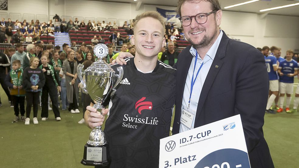 Oberbürgermeister Tim Kruithoff übergibt hier den Pokal für Rang drei an RW Emden/Kickers II.