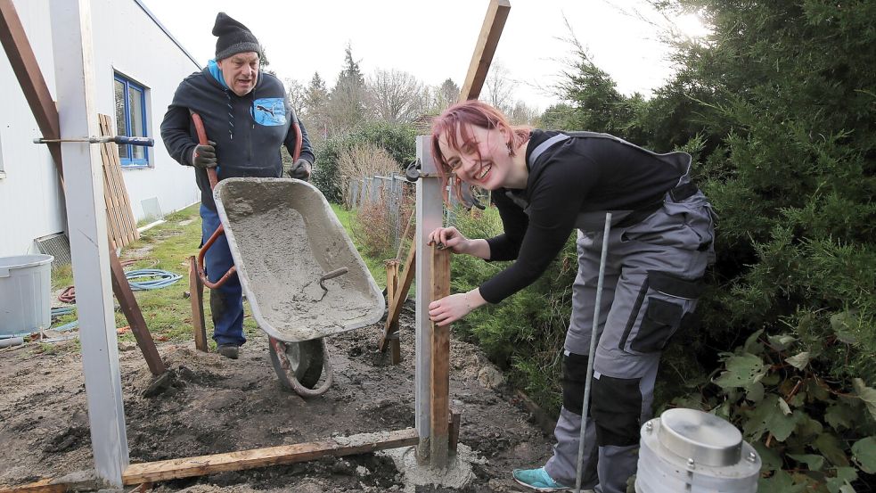Helwig Loers und Julia Barwig bauen am Eingang der Theaterstuuv in Wiesmoor den Sichtschutz zum Garten. Viele Arbeiten erledigten die Ehrenamtlichen in Eigenregie. Foto: Böning