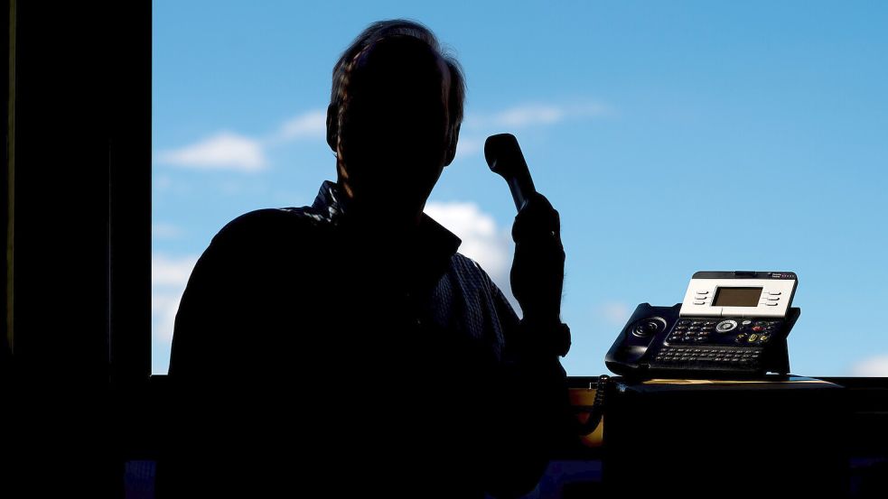 Ein Mann hält ein Telefon. Foto: DPA