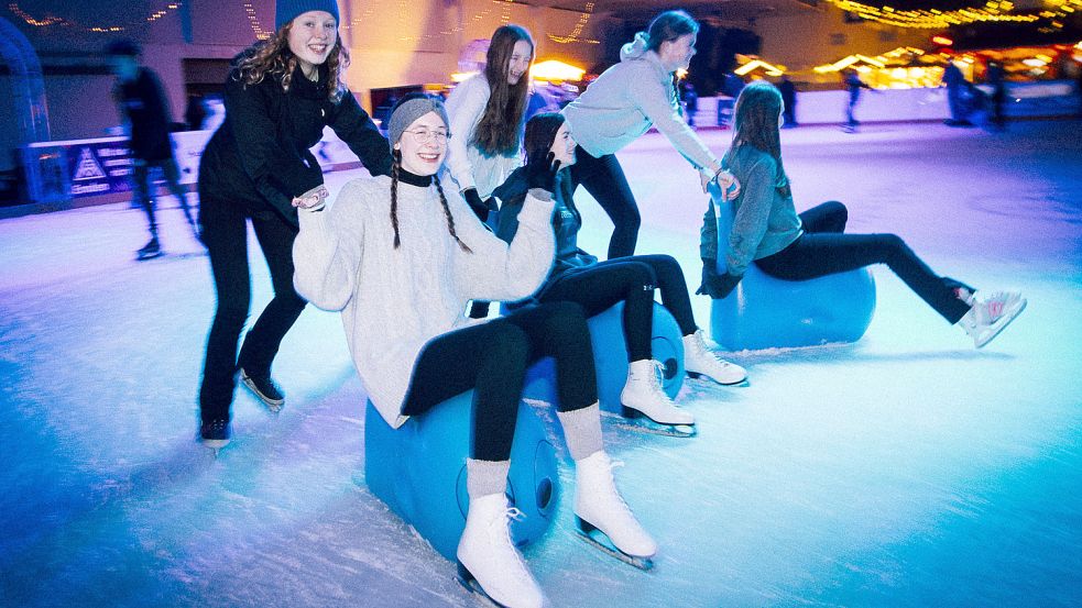 Auf dem Eis hatten am Samstag als erste vor allem Jugendliche aus Emden ihren Spaß. Diese Gruppe stellte fest, dass sich die blauen Anfängerhilfen auch prima zum Gleiten im Sitzen eignen. Fotos: Jens Doden