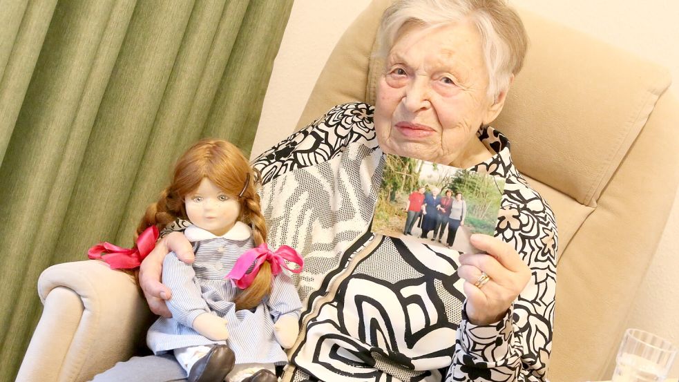 Eva-Maria Reichert in ihrem Zimmer mit einer ihrer ersten selbst gebastelten Puppe und einem Familienbild. Foto: Böning