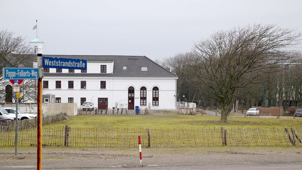 Blick auf ein leeres Baugrundstück an der Weststrandstraße auf Norderney. Die Unternehmerfamilie Brune plant dort im historischen Kurareal neben dem Conversationshaus (weißes Gebäude) ein Hotel mit dem Namen „LUV“. Foto: Volker Bartels/dpa